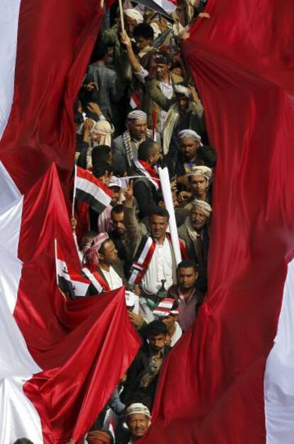Un grupo de yemen&iacute;es sujetan una bandera gigante, durante las marchas en San&aacute;.