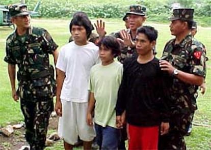 Oficiales filipinos, con tres rehenes de Abu Sayyaf que acaban de ser liberados en la provincia de Basilan (sur).