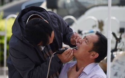 Un dentista atiende a un paciente en las calles de Pekín, la semana pasada.