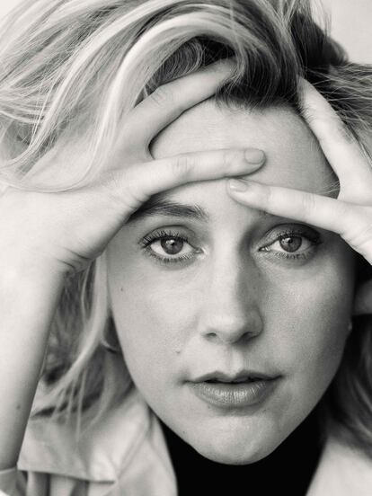 Greta Gerwig lleva abrigo de Lafayette 148, jersey y falda de REFORMATION y pendientes de MONICA VINADER.