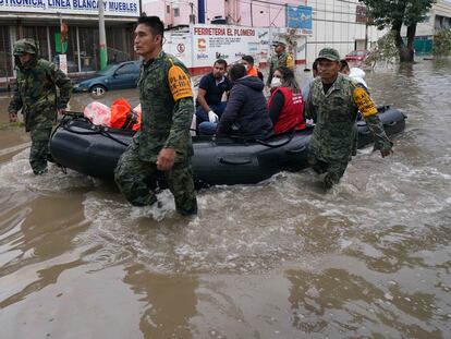 Soldiers move health workers on an inflatable boat on a flooded street in Tula, Hidalgo state, Mexico, Tuesday, Sept. 7, 2021. Torrential rains in central Mexico suddenly flooded a hospital in Tula, killing more than a dozen patients, with about 40 other surviving as waters rose swiftly and flooded the public hospital. (AP Photo/Marco Ugarte)