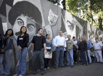 Varios ciudadanos hacen cola para votar en Caracas.