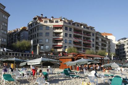 Playa de Silgar y al fondo, con toldos granates, el edificio levantado por la constructora de Telmo Martín.