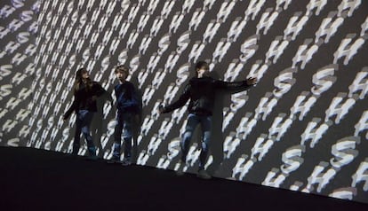 Tres visitantes interactuando con la obra 'Surround Sounds' de Christian Marclay.