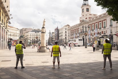 Hombres anuncio de Compro Oro en la entrada a la Puerta del Sol de Madrid desde la calle del Arenal.