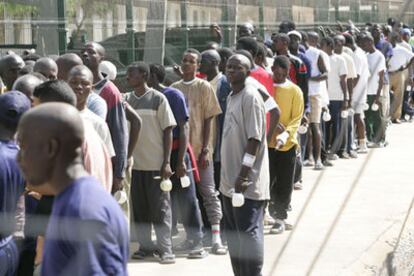 Inmigrantes subsaharianos aguardan el turno de comida en el centro de estancia temporal de Melilla.