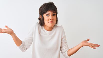 Young beautiful woman wearing casual t-shirt standing over isolated white background clueless and confused expression with arms and hands raised. Doubt concept.