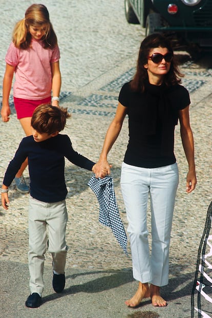 Nadie como ella transforma una camiseta básica negra y un pantalón blanco capri en un look icónico. Los pies descalzos, paseando por las calles de la isla griega Skorpios, terminan por convertir esta elección en una de sus apariciones más casuales e inspiradoras. Fue el conjunto que llevó el día antes de su boda con su segundo marido, Aristóteles Onassis.