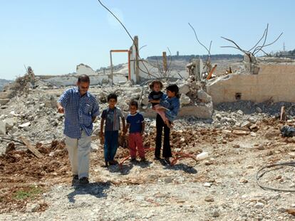 Meir Margalit, acompañado de un grupo de niños, entre las ruinas de viviendas palestinas derribadas por los israelíes.