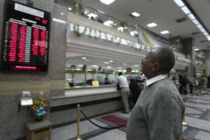 Un hombre revisa un panel con el valor alcanzado por varias divisas en un banco de El Cairo (Egipto) hoy, lunes 31 de diciembre de 2012.
