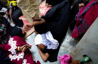 Un jeque de la clínica de hierbas de Shifaa sostiene a una mujer que etá siendo tratada por lo que cree que es posesión de espíritus. La mujer tuvo convulsiones y cayó al suelo durante el proceso.