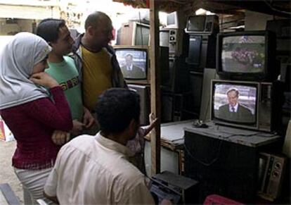 Varios residentes en el campo de refugiados de Sabra, en Beirut, siguen la conmemoración por televisión.