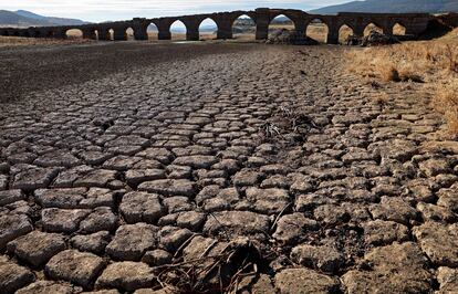 Part of the Guadiana river has dried up and gives way to dry land under the Puente de la Mesta medieval bridge in Villarta de los Montes, in the central-western Spanish region of Extremadura