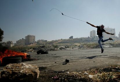 Un manifestante palestino utiliza una honda para lanzar piedras a las tropas israelíes durante enfrentamientos en Cisjordania, el 11 de mayo de 2017.