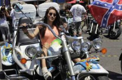 Una mujer sobre una Harley Davidson con motivos de Gaudí, hoy en la Avenida María Cristina, en Barcelona, a donde han comenzado a llegar hoy miles de motoristas para la quinta edición del Barcelona Harley Days, la mayor concentración de este tipo de vehículos que se organiza en Europa, que se celebrará mañana con la asistencia de unos 21.000 participantes.