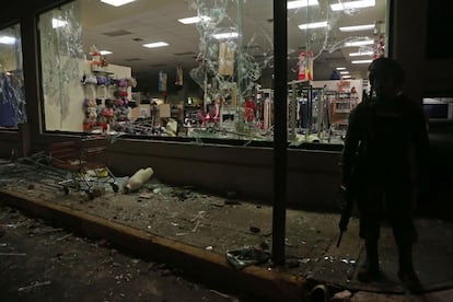 Un militar de la Marina frente a una tienda saqueada de Veracruz (México).