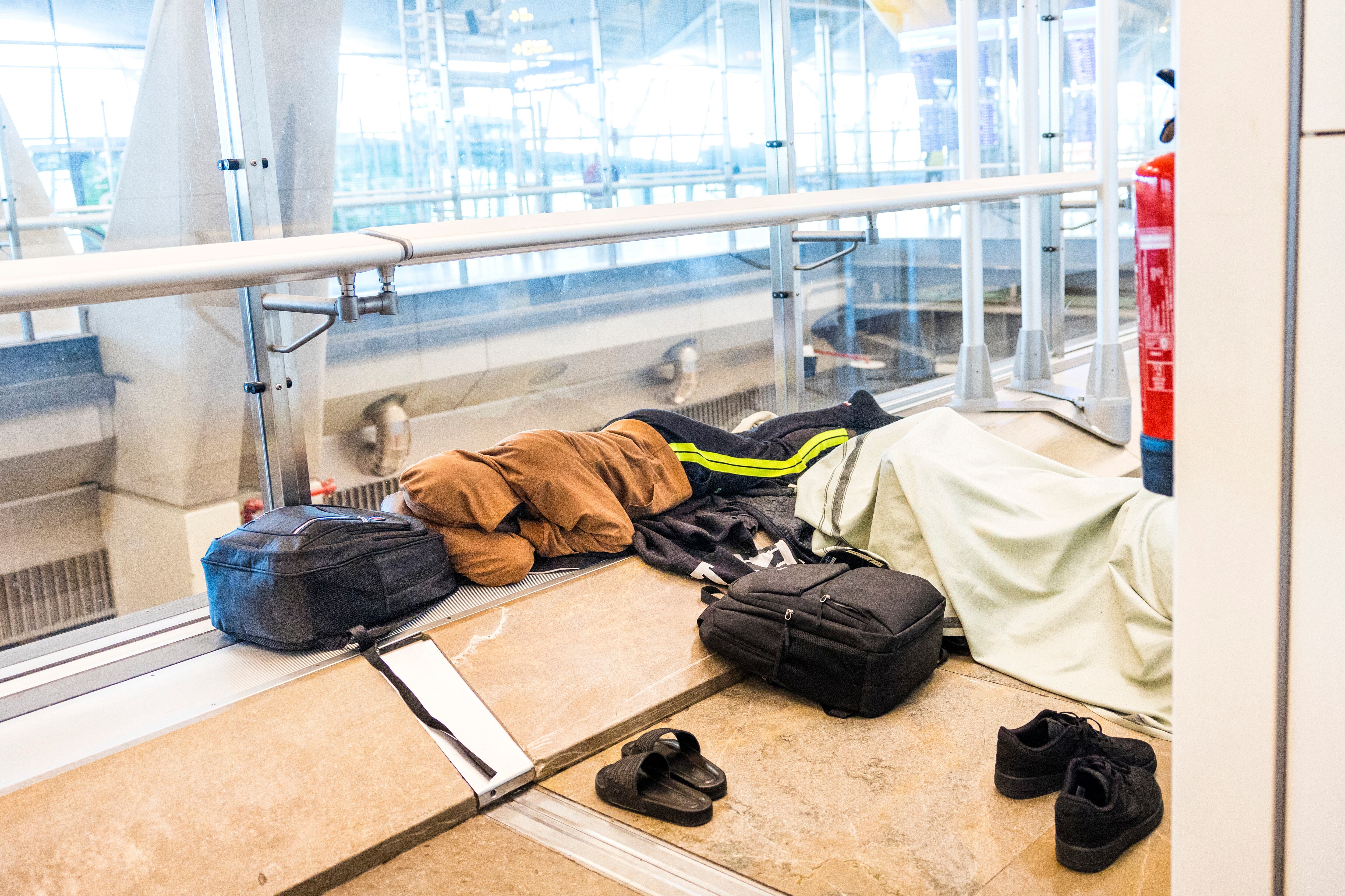 Dos migrantes duermen en un pasillo de la zona de tránsito de la T4 de Barajas.