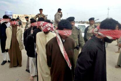 Un grupo de prisioneros son conducidos por soldados iraquíes a un centro de detención en Nayaf.