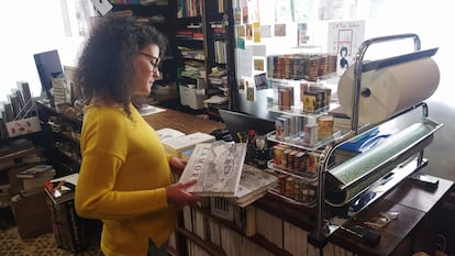 Judit Pino ojea un libro en su librería.