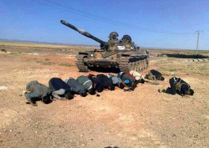 Rebeldes sirios rezan junto a un tanque en la provincia de Deraa.