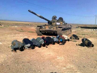Rebeldes sirios rezan junto a un tanque en la provincia de Deraa.