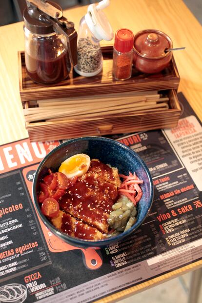 El 'donburi' de lomo de cerdo empanado lleva encurtidos japoneses, tomate cherri, huevo semi cocido, salsa tonkatsu y una cama de arroz.