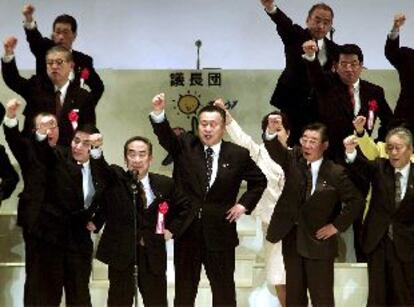 Yoshiro Mori (centro), junto a abogados de su partido, levantan el puño en su convención en Tokio.