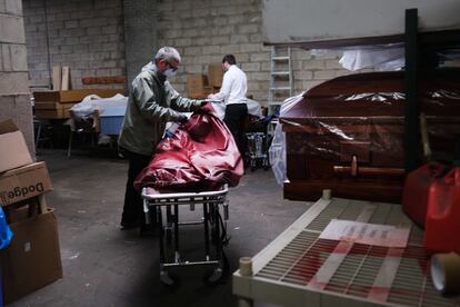 Dos trabajadores de una funeraria en Nueva York preparan el cuerpo de una fallecida por coronavirus.