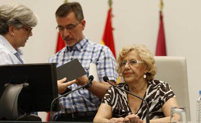 La alcaldesa, Manuela Carmena, flanqueada por dos trabajadores municipales.