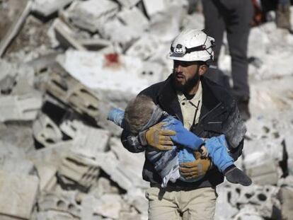 Un hombre lleva el cad&aacute;ver de un ni&ntilde;o tras un bombardeo atribuido a las fuerzas rusas, este s&aacute;bado en Idlib (Siria).