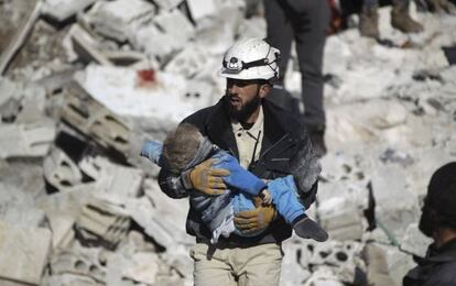 Un hombre lleva el cad&aacute;ver de un ni&ntilde;o tras un bombardeo atribuido a las fuerzas rusas, este s&aacute;bado en Idlib (Siria).