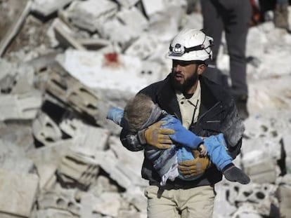 Un hombre lleva el cad&aacute;ver de un ni&ntilde;o tras un bombardeo atribuido a las fuerzas rusas, este s&aacute;bado en Idlib (Siria).