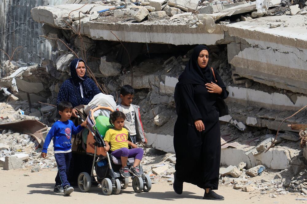 Palestinian women and children make their way with belongings as they flee their homes after the Israeli military issued orders for evacuation from eastern Khan Younis, in the southern Gaza Strip, May 19, 2025. REUTERS/Hatem Khaled