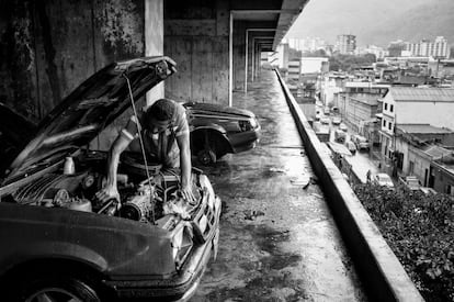 O estacionamento serve como oficina para alguns habitantes da torre.