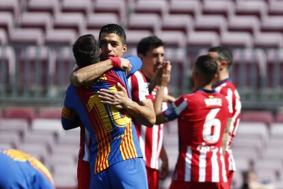 El jugador del Atlético de Madrid Luis Suárez abraza a su excompañero en el Barcelona Leo Messi (de espaldas), antes del partido.