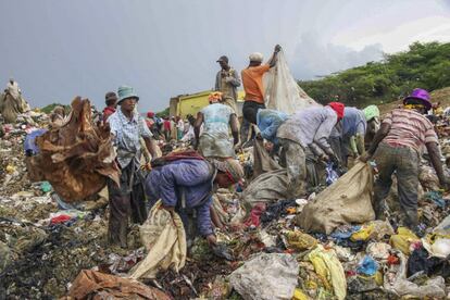 Los recicladores se agolpan donde descargan los camiones de la basura.