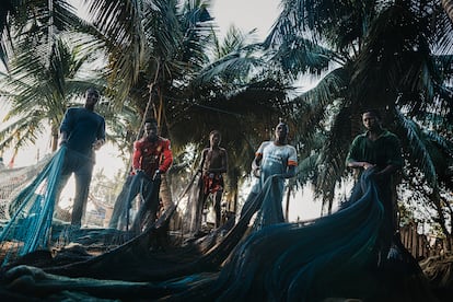 Kessah Amevor, de 11 años, junto a algunos miembros de la tripulación de la barca Believe, apura sus últimos momentos antes de ir a la escuela. Muchos niños trabajan por la noche para contribuir a la economía familiar e incluso costearse sus propios estudios. Muchos terminan abandonando tempranamente la escuela. 