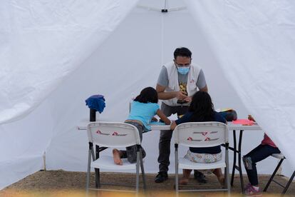 Un integrante de Médicos Sin Fronteras da atención psicologica a niñas en un campamento de migrantes en Reynosa, en mayo de 2021.
