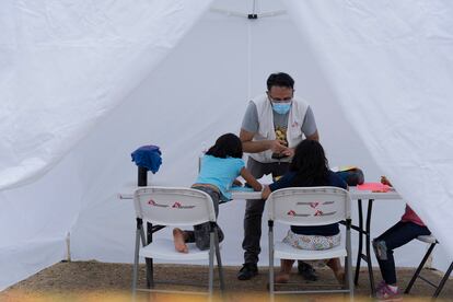 Un integrante de Médicos Sin Fronteras da atención psicologica a  niñas en un campamento de migrantes en Reynosa, en mayo de 2021.