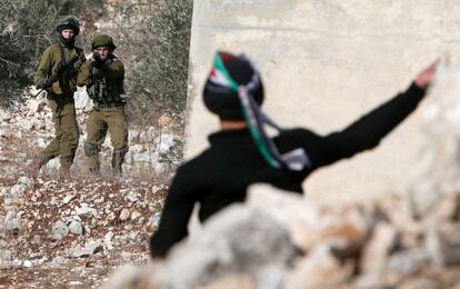 Un hombre palestino protesta lanzando piedras contra las fuerzas de seguridad israelíes tras una manifestación contra la expropiación israelí de la tierra Palestina , en el municipio de Kfar Qaddum (Cisjordania).