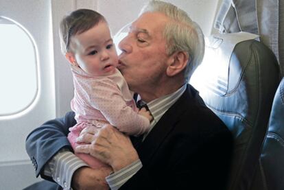 Mario Vargas Llosa sostiene a su nieta en brazos, en el viaje a Estocolmo para recoger el Premio Nobel.