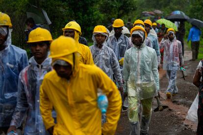 Rescuers walk towards the site of a landslide in Raigad district, western Maharashtra state, India, Thursday, July 20, 2023