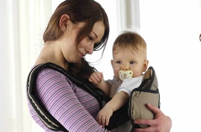 Madre portea en una mochila a su bebé.