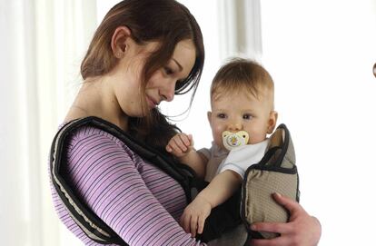  Madre portea en una mochila a su bebé.