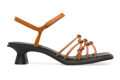 Dina, las sandalias (para) debutantes.
Eran los tacones de entrenamiento hacia la edad adulta. Antes de que las chicas se atrevieran con los vertiginosos stilettos, los kitten heels eran sus zapatos de principiantes. En esta revuelta (aunque quizá sería más correcto decir transición) por la comodidad, el tacón más bajo y sofisticado ha vuelto con fuerza. Camper los esculpe en caucho, con forma cuadrada y una altura de 2,9 cm para crear, precisamente, sus sandalias debutantes. De espíritu informal y aspiraciones artesanas, este modelo de Dina, de piel con certificación Leather Working Group, recoge el legado estético marinero y sus complejos nudos náuticos.