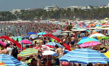 Imagen de una playa repleta de turistas al inicio de las vacaciones. 