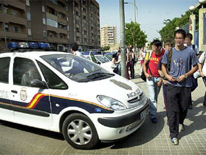 Un coche de la Policía Nacional, ayer a la salida del instituto de Orriols, a cuyas puertas se concentra un grupo que amenaza a estudiantes inmigrantes.