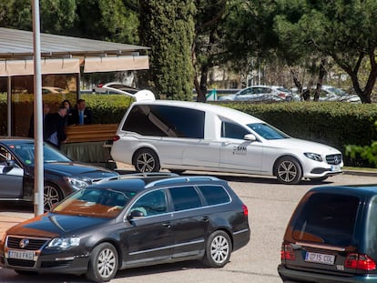 Empleados de la funeraria municipal introducen el féretro de un muerto por coronavirus en un coche, en el Tanatorio Sur de Madrid