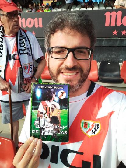 Jesús Mesado en el campo del Rayo Vallecano con su novela 'El samurái de Vallecas'.