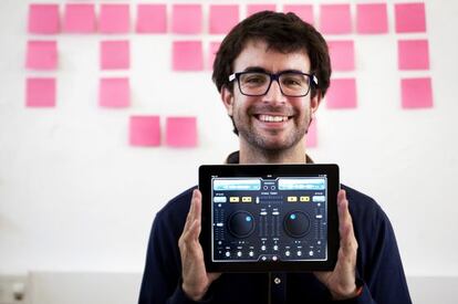Nacho Sánchez holds up a tablet computer running his company's app Deej.